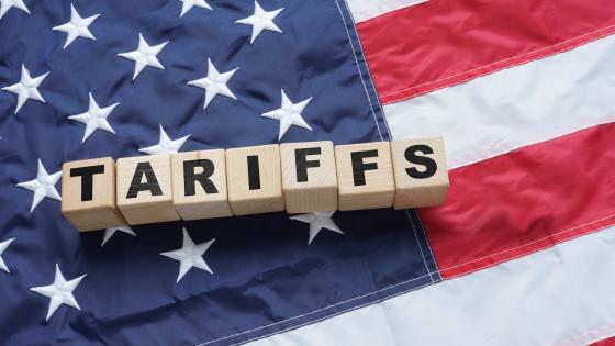Tariffs written on wooden cubes on American flag