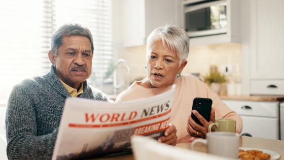 Couple reacting to bad news in newspaper