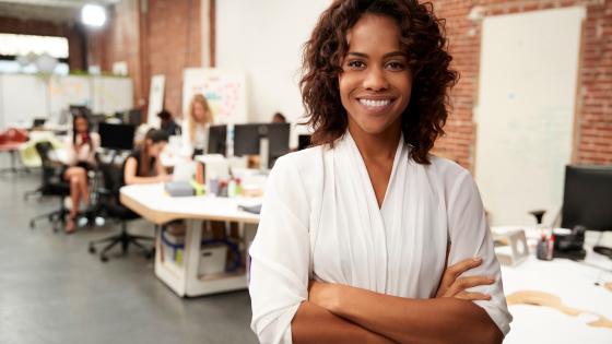 Woman standing in front of her team in open plan office