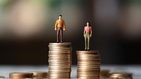 Figures of a man and woman on unequal stacks of coins