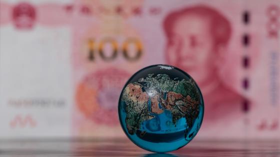 Glass globe in front of Chinese currency