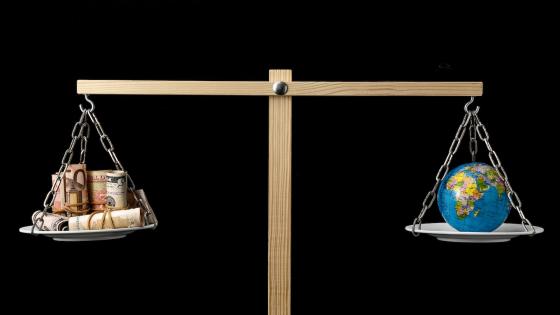 Globe and currencies on a Two Pan Balance